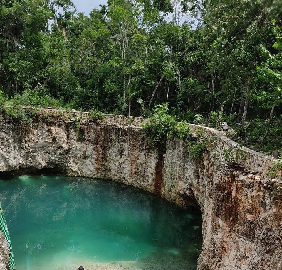 Lote ecológico de 1,000 m² en la Ruta de los Cenotes, Puerto Morelos. Incluye cenote y río en comunidad, seguridad privada y energía solar. Entrega inmediata.